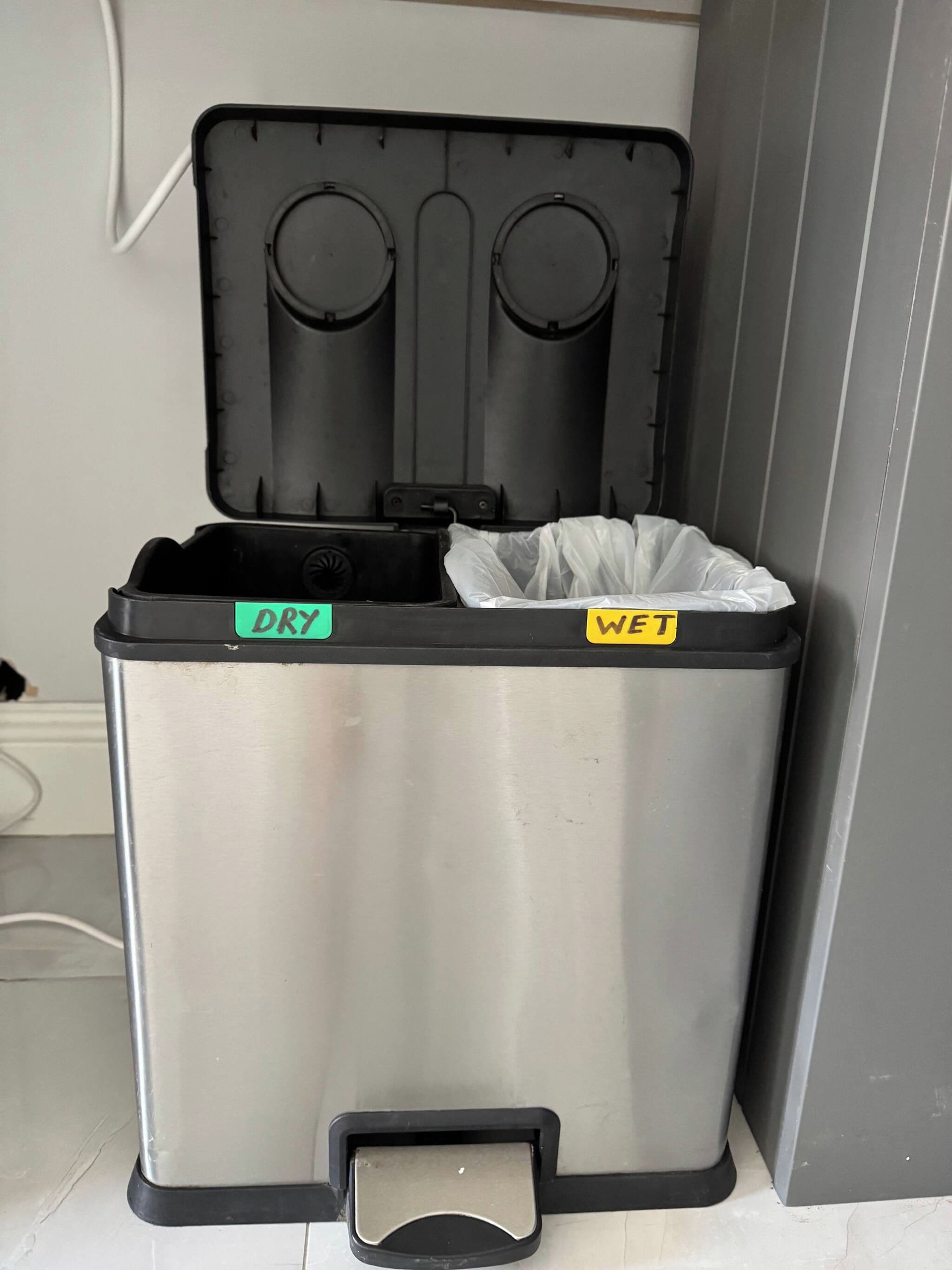 A trash bin with two compartments labeled 'DRY' and 'WET.'