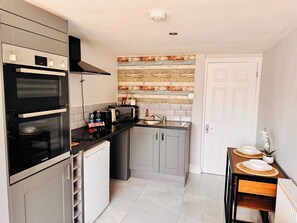A compact kitchen with a Bosch oven, a coffee maker, and a toaster. - Shal Inn at Heathrow Free Parking and Ride on Request (Slough)