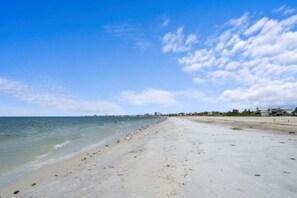 A beach with a clear sky and calm sea. - Sunset 100- Beautiful Beachfront 2-Bedroom Condo (Fort Myers Beach)