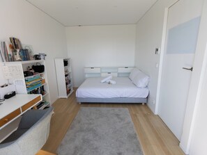 A bedroom with a bed, a desk, a bookshelf, and a wardrobe. - Le Rooftop Eiffel & La Défense - Welkeys (Neuilly-sur-Seine)