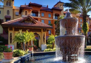 A fountain in front of a hotel with a tiled roof and multiple balconies. - 1BR DELUXE sleeps 4- Holiday Get Away 5min to Disney-Wyndham Bonnet Creek Resort (Lake Buena Vista)