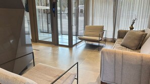 A modern interior with a sofa, armchair, and a staircase leading to an outdoor area. - Elegant studio with a beautiful view. (Porto Alegre)