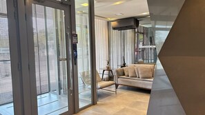 A modern interior with a glass door, a sofa, and a small table. - Elegant studio with a beautiful view. (Porto Alegre)