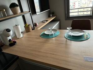 A dining table set with plates, cutlery, and a glass. - Elegant studio with a beautiful view. (Porto Alegre)