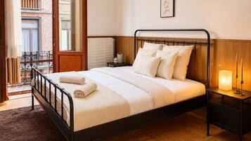 Une chambre à coucher avec un lit, une table de chevet et une vue sur l’extérieur.