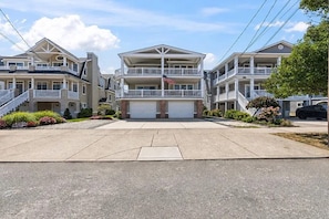 A residential building with a central garage, multiple balconies, and a flag. - Near Beach 4BR OCNJ Retreat / Rooftop Deck & Garage (Ocean City)