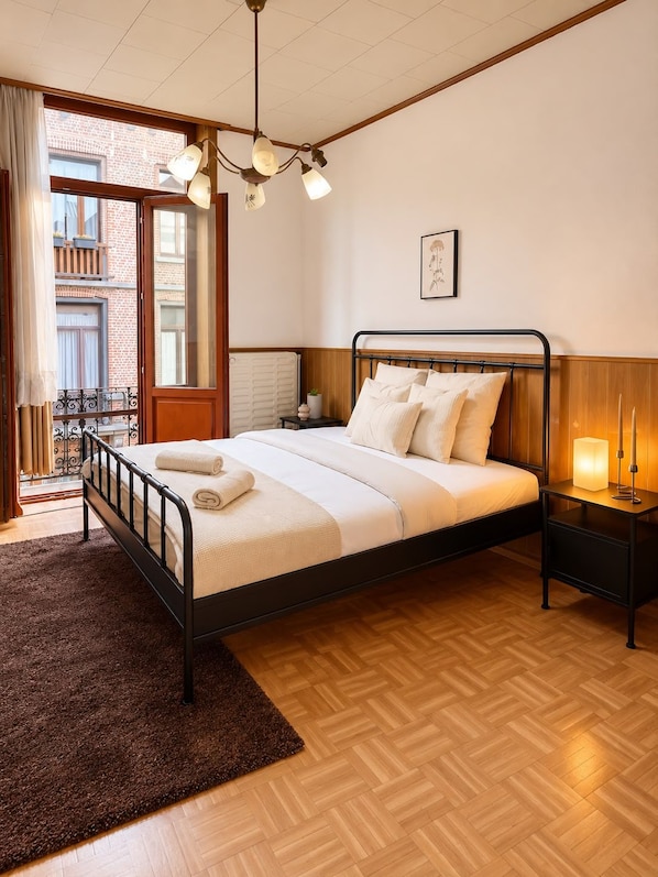 Un dormitorio con cama, mesita de noche y vistas al exterior.