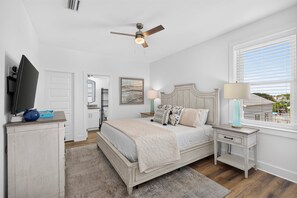 A bedroom with a bed, bedside tables, a ceiling fan, a window with blinds, and a television on a stand. - Coastal Paradise - Miramar Beach Escape with Pool & Golf Cart (Miramar Beach)
