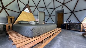 A room with a bed on wooden pallets, a wooden headboard, and a geometric ceiling design. - Casa Libelula - Eco Glamping - Valle de Bravo (Valle de bravo)