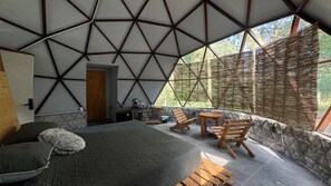 A room with a bed, a small table, and a chair. There is a door leading to another room. - Casa Libelula - Eco Glamping - Valle de Bravo (Valle de bravo)