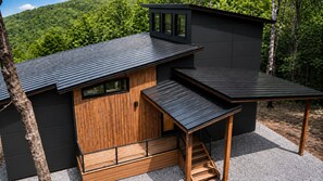 A modern cabin with a wooden exterior, a sloped roof, and a small deck. - 2-bedroom house. Altamont TN. (Altamont)