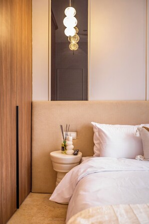 A bedroom with a bed, a bedside table with a lamp, a toilet, and a mirror. - Stylish apartment with a warm atmosphere (Marrakesh)