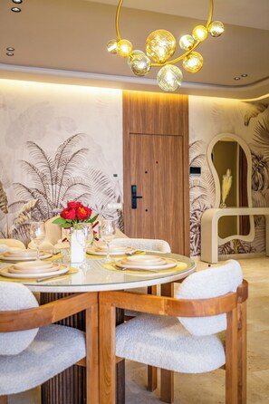 A dining area with a round table set for four, surrounded by wooden chairs. - Stylish apartment with a warm atmosphere (Marrakesh)