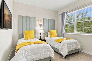 A hotel room with two beds, a window with curtains, a painting on the wall, and a lamp. - Stay Central, Explore More, Orlando 3BR Condo (Orlando)