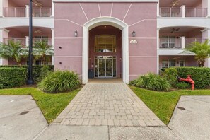 A building entrance with a glass door, a number sign, and a pathway leading to it. - Spacious 3BR in Prime Orlando Location (Orlando)
