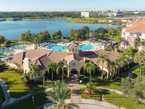 A resort with a swimming pool, palm trees, and a view of a lake. - Spacious 3BR in Prime Orlando Location (Orlando)
