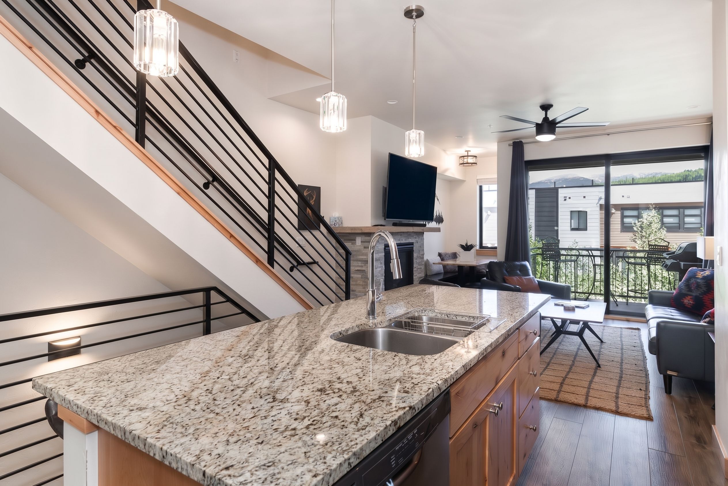 A modern kitchen with granite countertops, a built-in dishwasher, and a large island with a sink.