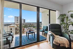 Airy living room opening onto the balcony with city and ocean views - Seventh Heaven: 7th-Floor Ocean View Condo with Beach Access & Heated Pool in Cocoa Beach (Cocoa Beach)