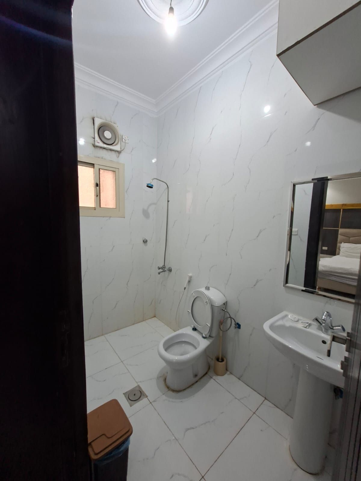 A bathroom with a toilet, sink, and shower.
