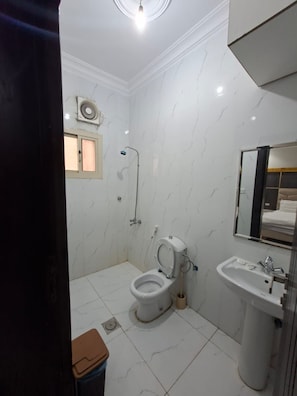 A bathroom with a toilet, sink, and shower. - Rahti Star 2 Serviced Apartments (taif)