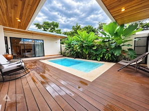 Pool and wooden deck with loungers, rocking chairs and tropical plants. - Casa Amarí: Private Pool, Rooftop Terrace and Three Ensuite Bedrooms (La Fortuna)