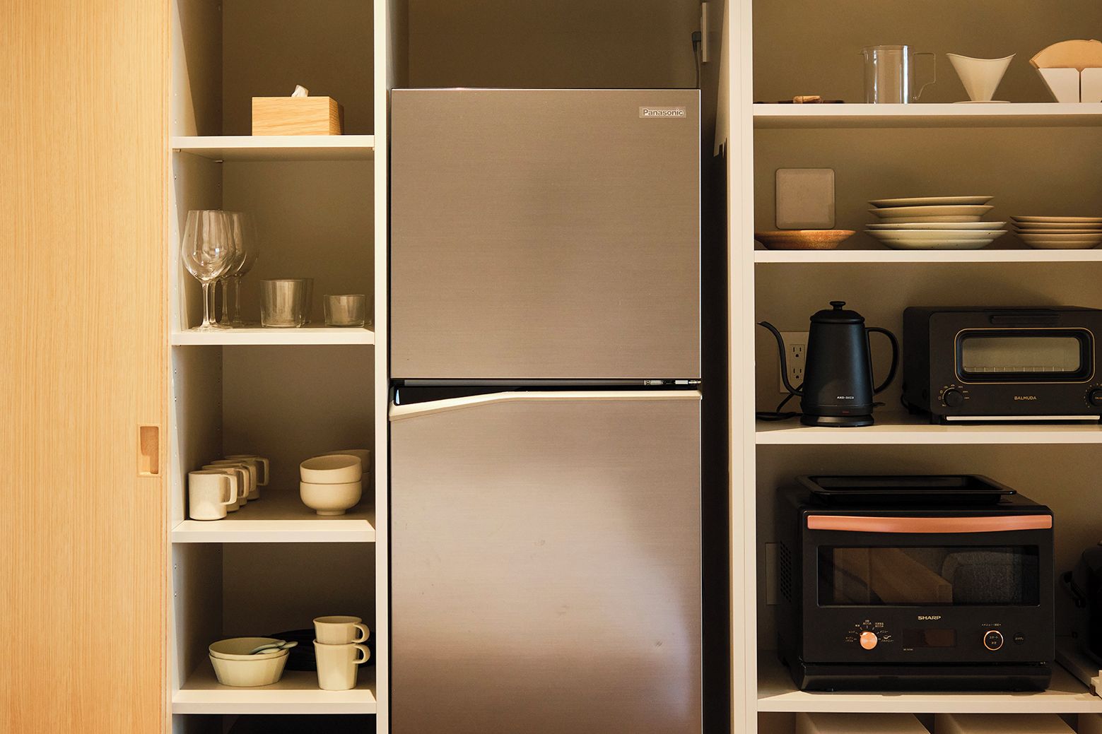 A kitchen with a refrigerator, microwave, and coffee maker.