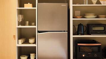 A kitchen with a refrigerator, microwave, and coffee maker.