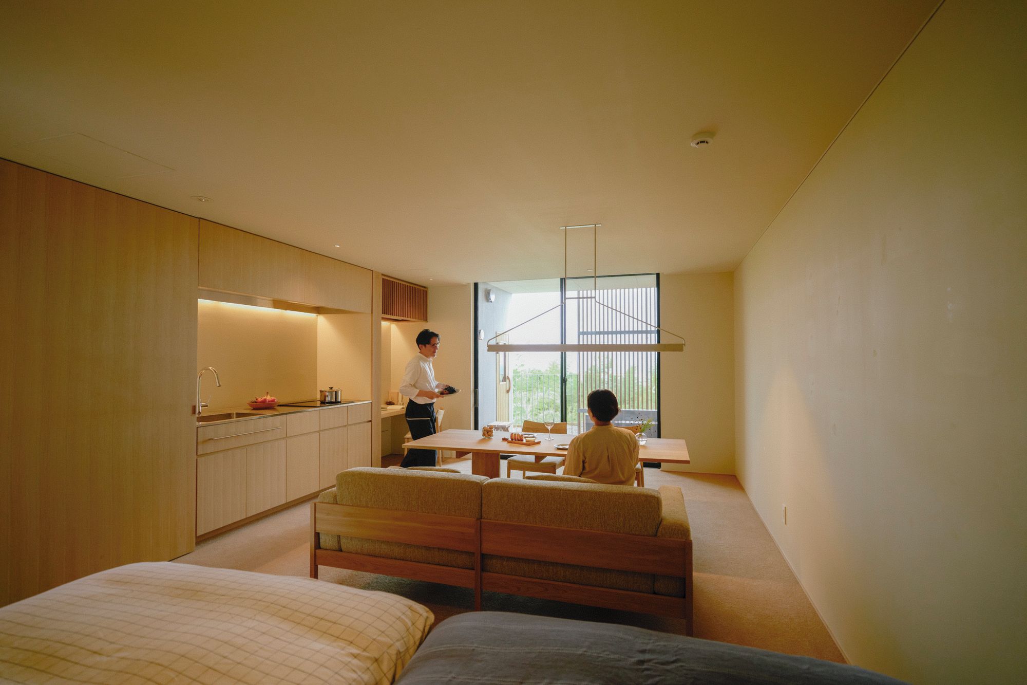 A modern bedroom with a bed, a desk, and a window.