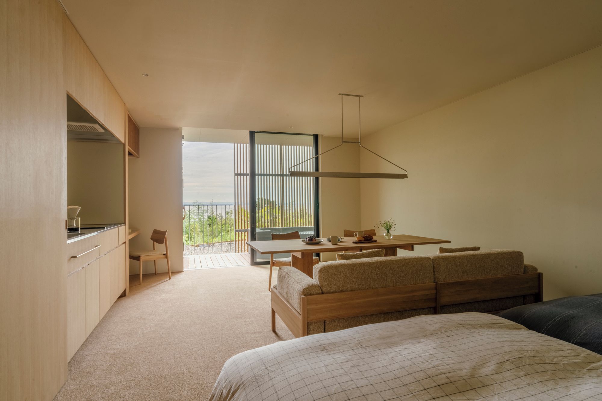 Una camera da letto moderna con un grande letto, una scrivania in legno e vista sull'esterno.