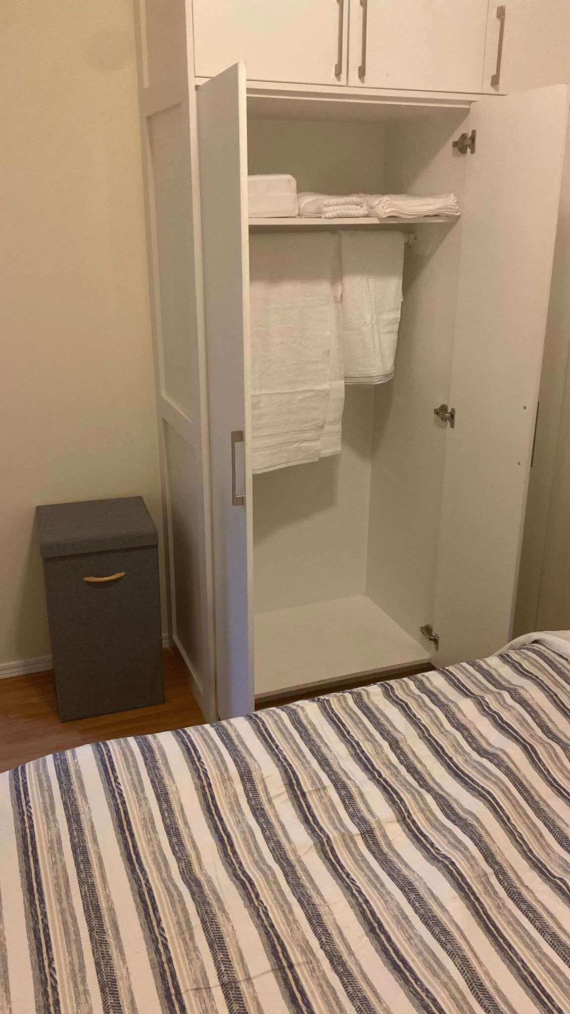 Une chambre à coucher avec un lit, une armoire et une petite boîte de rangement.
