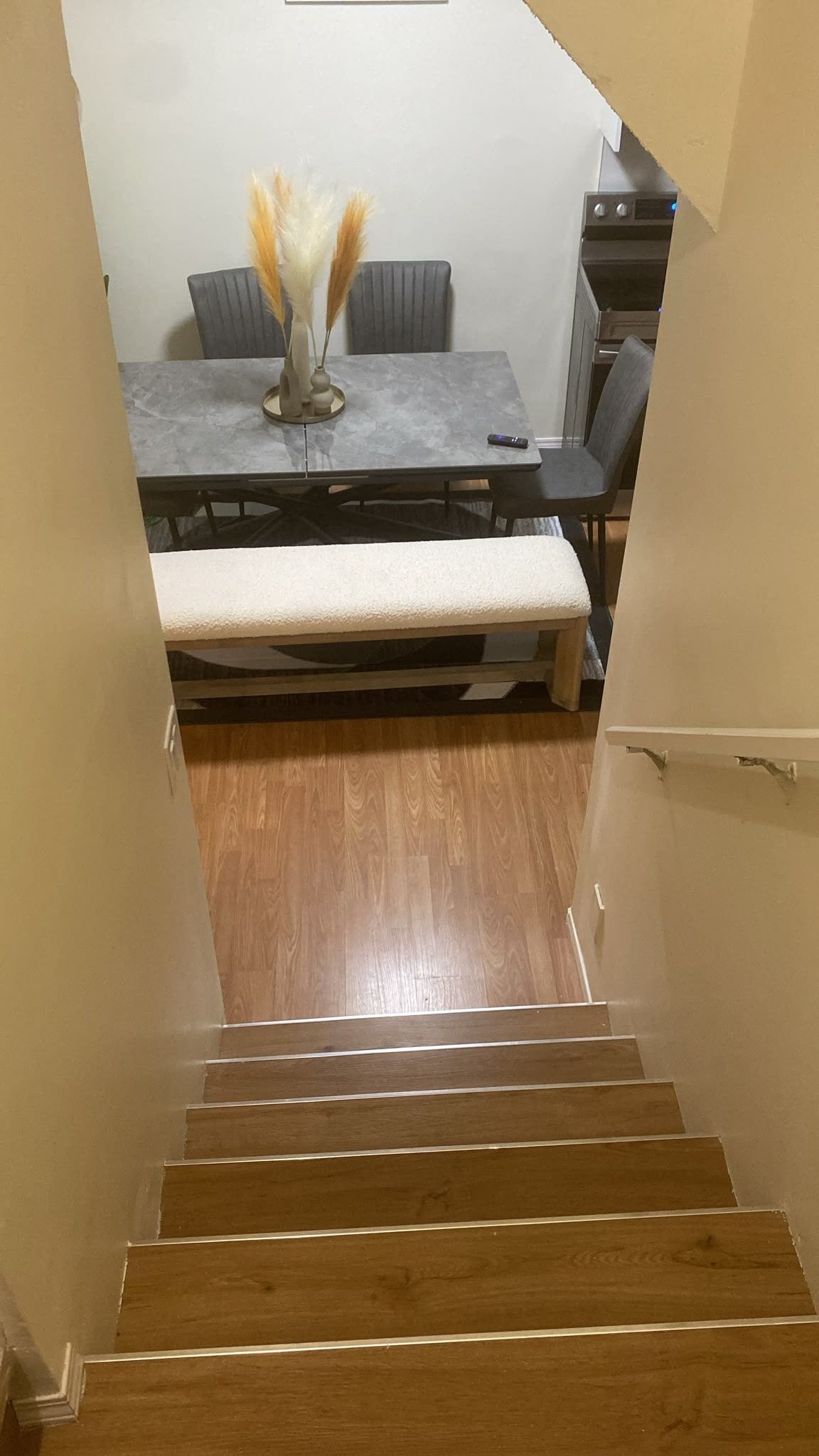Un escalier menant à une salle à manger équipée d’une table et de chaises.