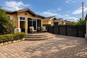 A residential property with a paved patio, a covered outdoor seating area, and a gated entrance. - Serenity Rest Modern 2-bedroom Gated Home near Falmouth, Montego Bay & Beaches (Falmouth)