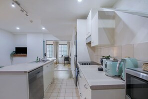 A modern kitchen with a dishwasher, a toaster, and a kettle. - Manhattan Loft Central Location with Gym and Sauna (Brisbane)