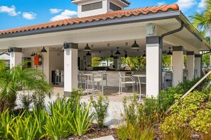 An outdoor patio area with a covered seating arrangement, a water feature, and a view of the surrounding greenery. - Stay Central Explore More Orlando 3BR Condo (Orlando)