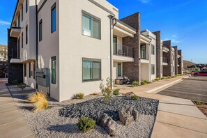 A modern multi-story residential building with a parking lot and landscaped area. - Terra P-11, Private Spa, Community Amenities w/ Water Slide! (Hurricane)