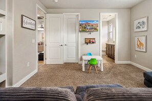 A home interior with a hallway leading to a dining area, a kitchen, and a living room with a sofa. - Paradise Village 102, Private Spa, Pool table, Foosball, Ping Pong and More! (Santa Clara)
