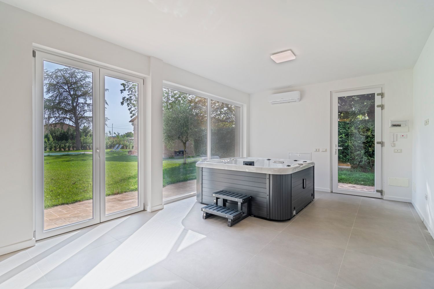 A modern bathroom with a large window, a built-in shower, and a toilet.