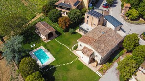 Ein Wohnhaus mit Schwimmbad, Garten und einer Solaranlage auf dem Dach.