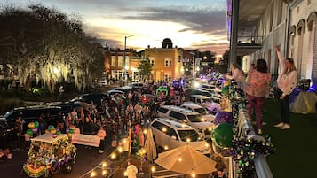 A crowded street scene with parked cars and a festive atmosphere.