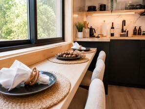 Eine Küche mit einer Holz Arbeitsplatte, einem Fenster und Blick auf Bäume.