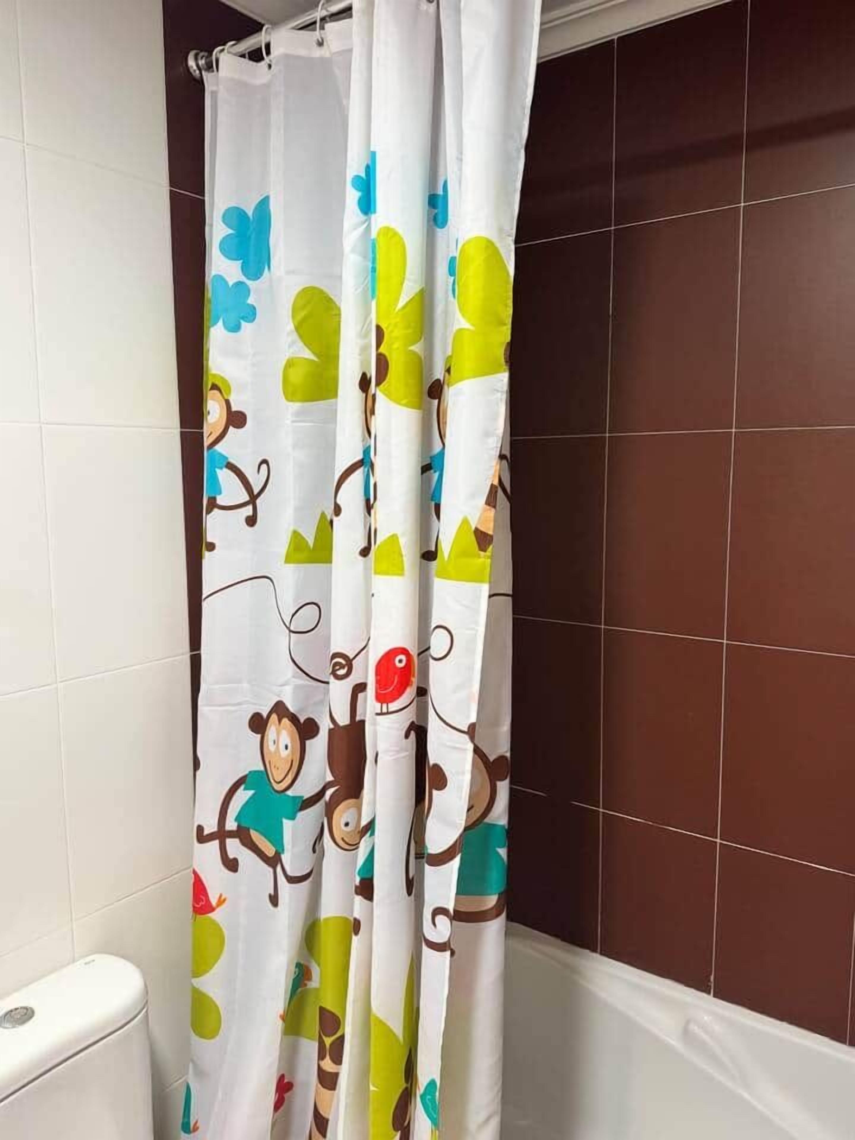 Een badkamer met een douchegordijn met een aapjesprint.