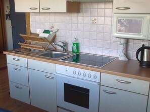 A kitchen with a sink, dishwasher, oven, and a microwave. - Gauenpark (Whg. Uehli), (Flumserberg Tannenheim), by Interhome (Flumserberg Tannenheim)