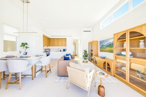 A modern interior with a dining area, kitchen, and living space. - Sunset House - Rooftop Ocean & Bay Views (San Diego)
