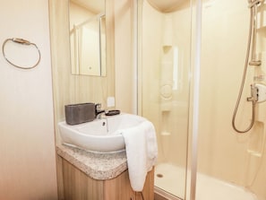 Ein Badezimmer mit Waschbecken, Spiegel und Dusche.