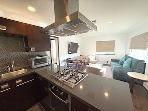 A modern kitchen with a central island, built-in oven, and stainless steel appliances. - Presidential Two Bedroom, Two Bath Suite (San Luis Obispo)