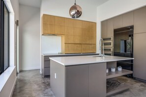 A modern kitchen with a central island, built-in oven, and stainless steel appliances. - Modern Oasis w Pool, Hot tub, Outdoors, Close to Austin and Dripping Springs (Austin)