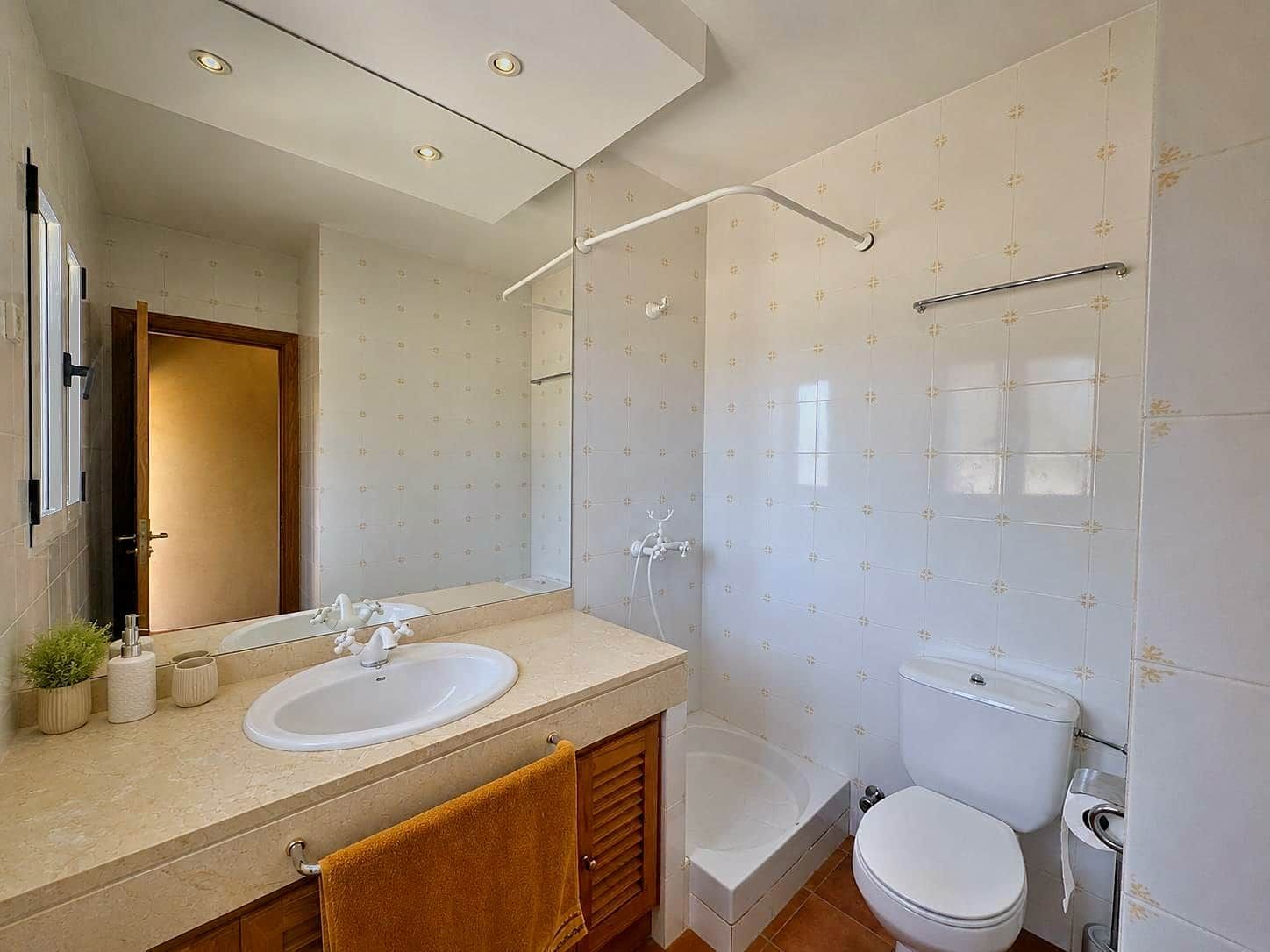 Een badkamer met een dubbele wastafel, een badkuip en een toilet.