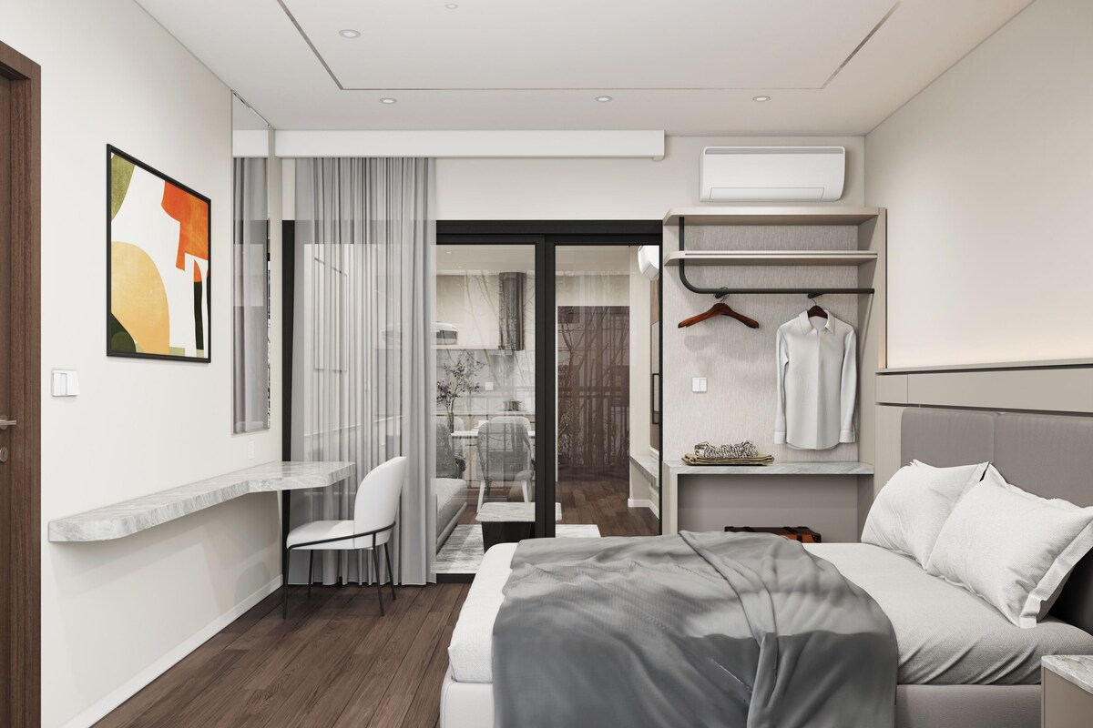 A modern bedroom with a bed, a desk, and a walk-in closet.