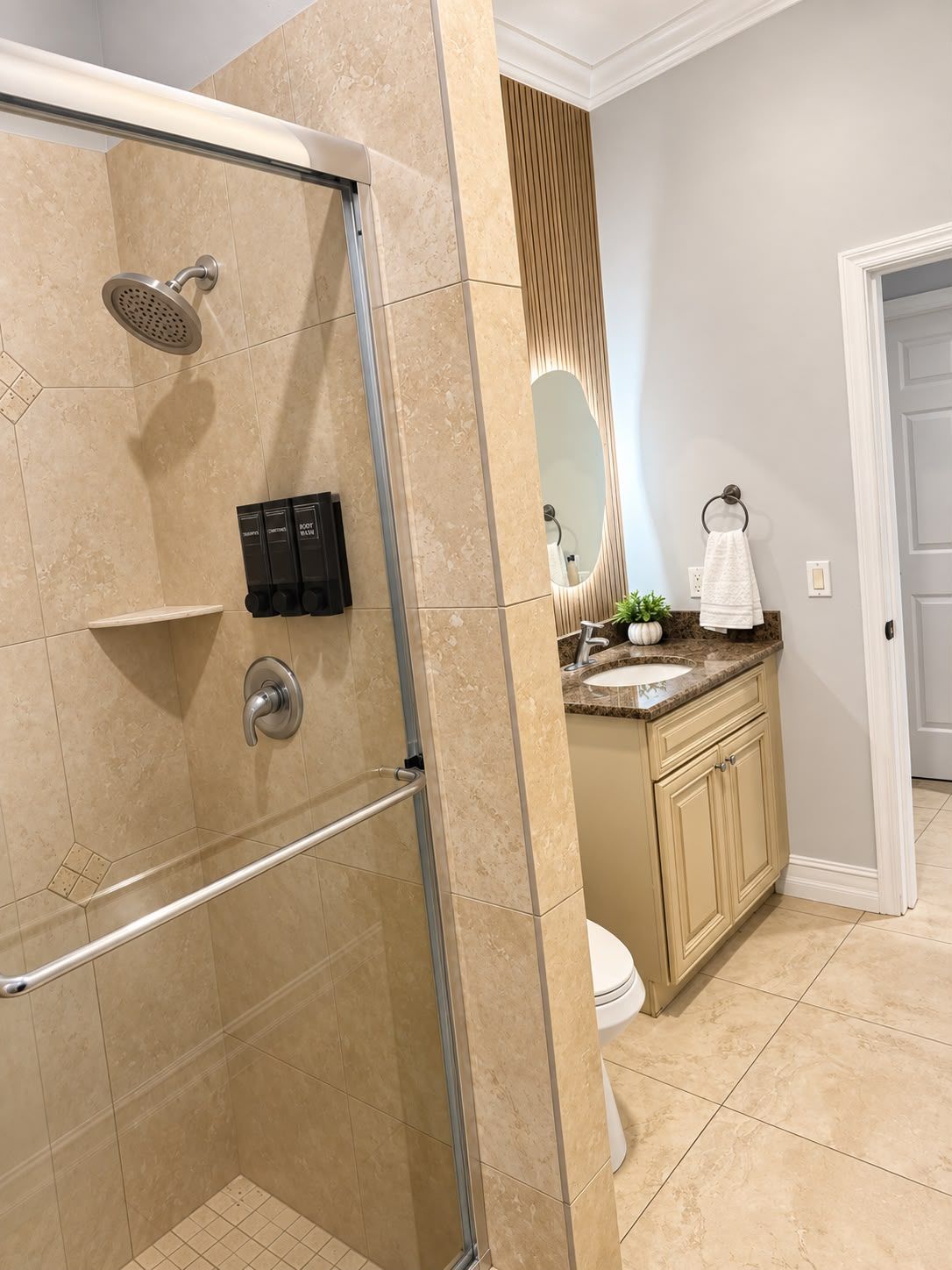 A bathroom with a shower, vanity, and toilet.