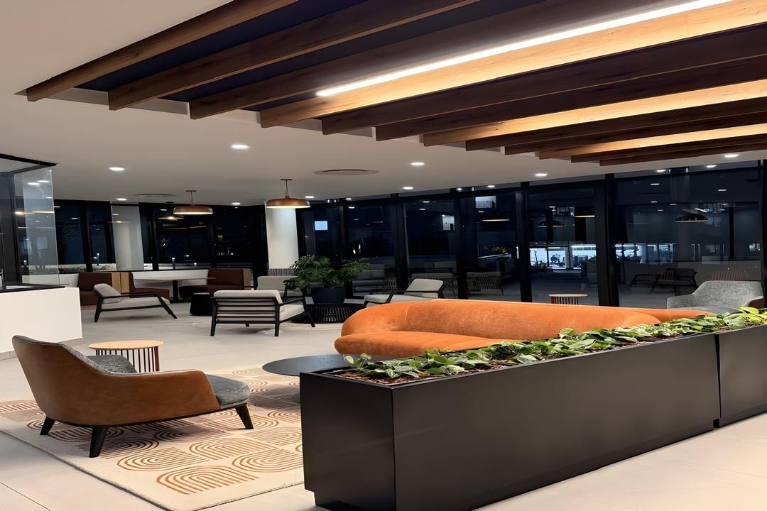 A modern lounge area with seating, a coffee table, and a planter with greenery.